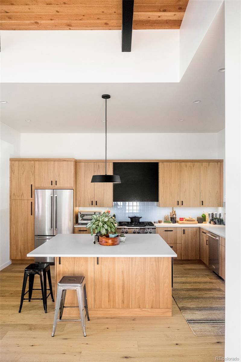 2977 Forest Street Denver, CO 80207 - Photo 4 of 23 a kitchen with a table chairs stove and cabinets