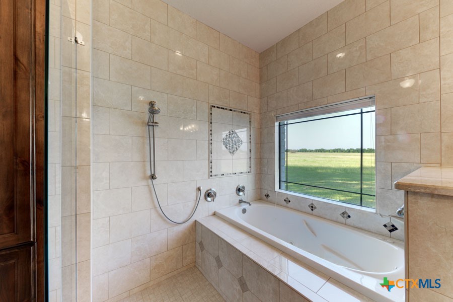 2420 Bolton Road Marion, TX 78124 - Photo 11 of 30 a bathroom with a tub a sink and a large window