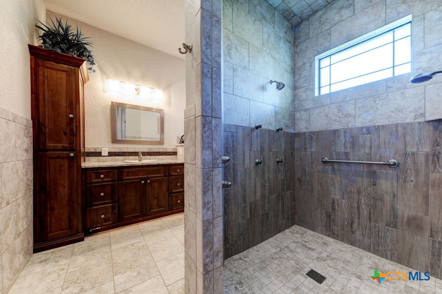 2420 Bolton Road Marion, TX 78124 - Photo 14 of 30 a bathroom with a sink a mirror and a shower