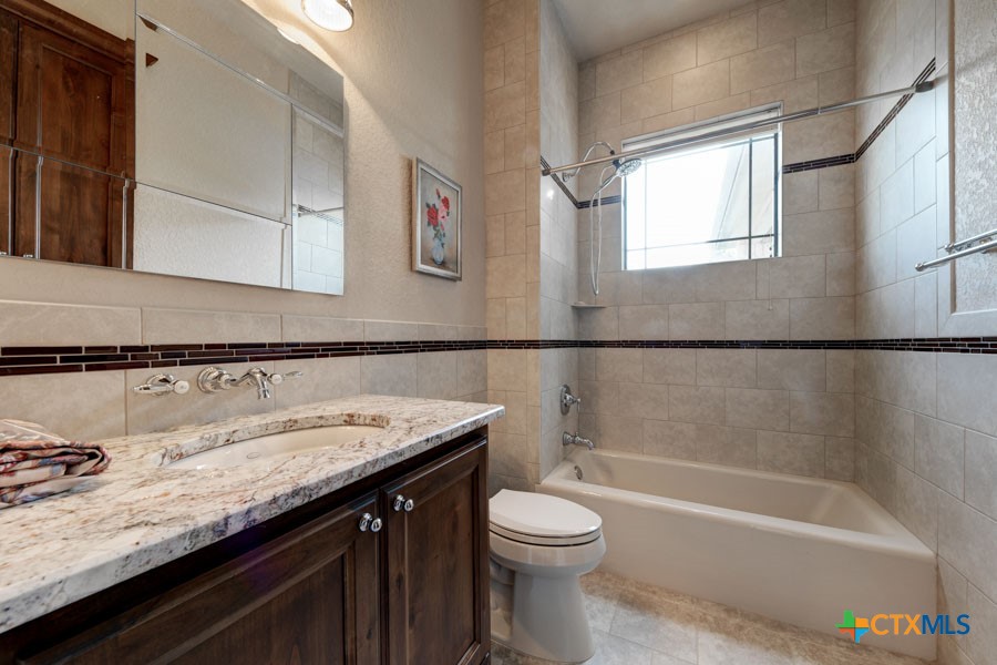 2420 Bolton Road Marion, TX 78124 - Photo 17 of 30 a bathroom with a granite countertop sink a toilet and bathtub