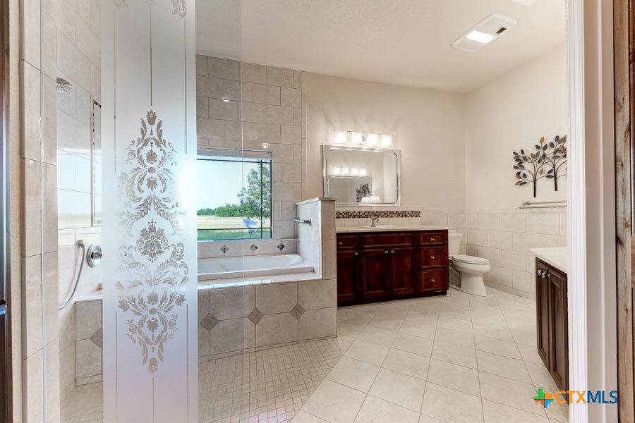 2420 Bolton Road Marion, TX 78124 - Photo 10 of 30 a spacious bathroom with a granite countertop sink a toilet and a bathtub