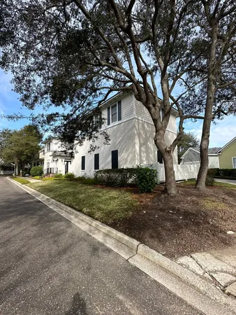 a white house that has a tree in front of it