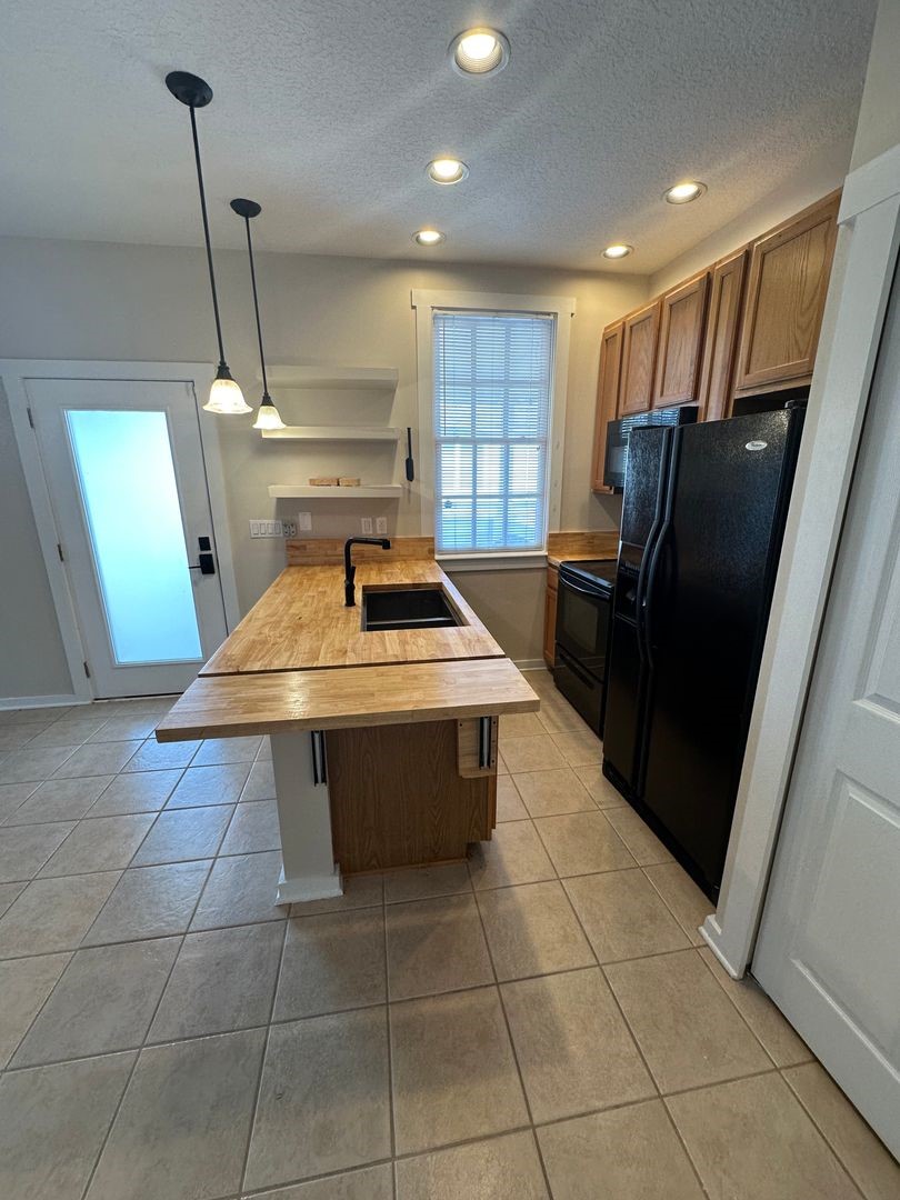 1896 Floyd Street Fernandina Beach, FL 32034 - Photo 13 of 16 a kitchen with a sink a refrigerator and window
