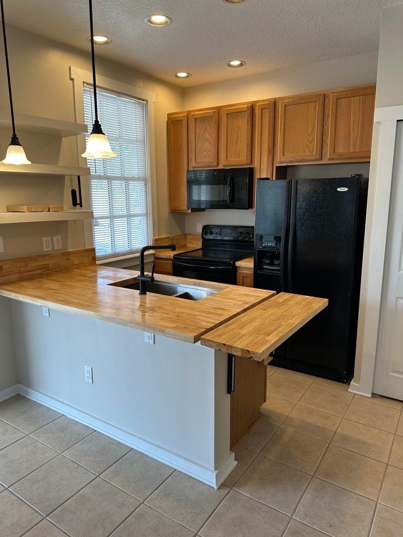 1896 Floyd Street Fernandina Beach, FL 32034 - Photo 2 of 16 a kitchen with stainless steel appliances a sink a counter top space cabinets and a wooden floor