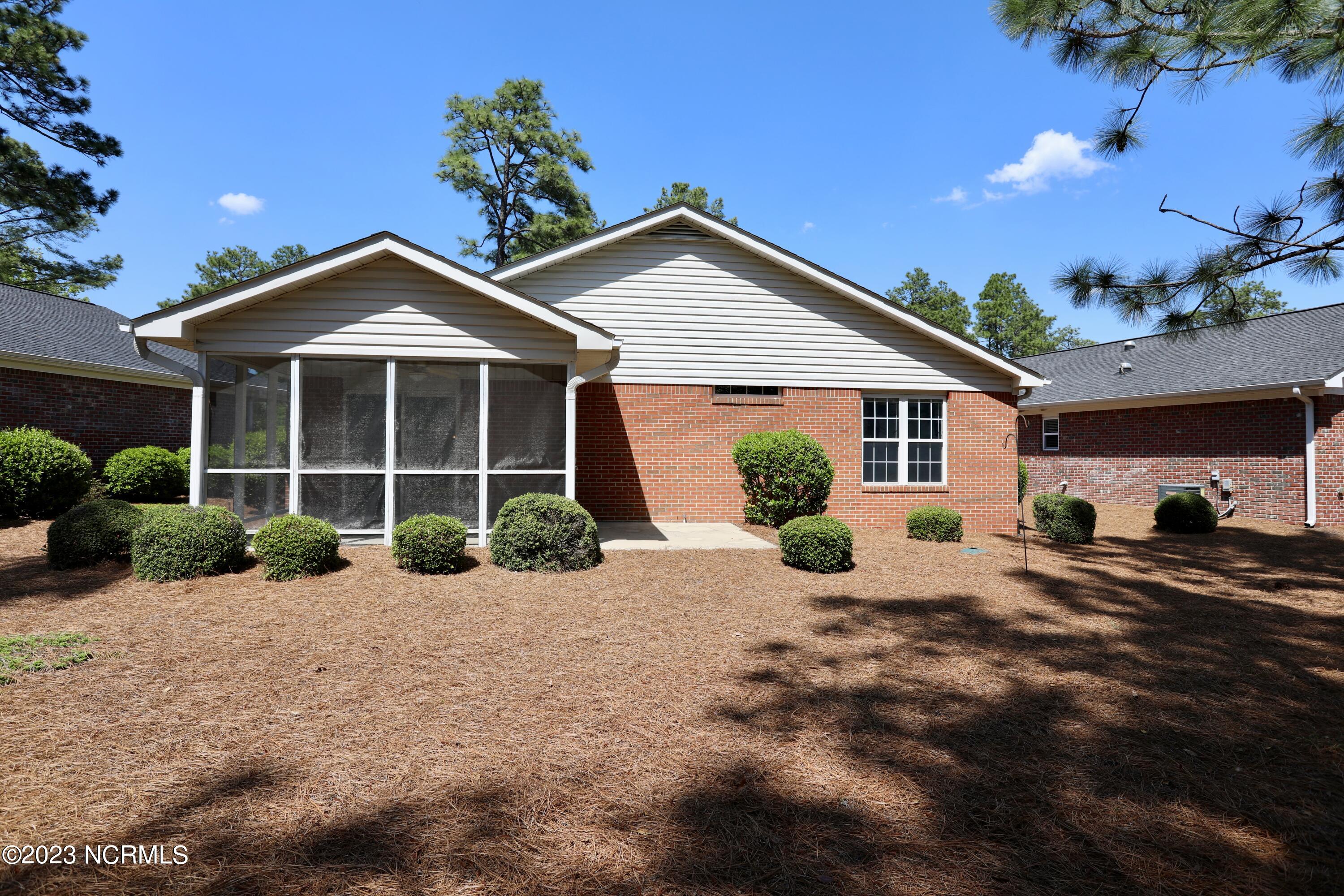 545 Pinehurst Trace Drive Pinehurst, NC 28374 - Photo 29 of 32 Exterior Back View of home's Screen Porch and Concrete Patio.