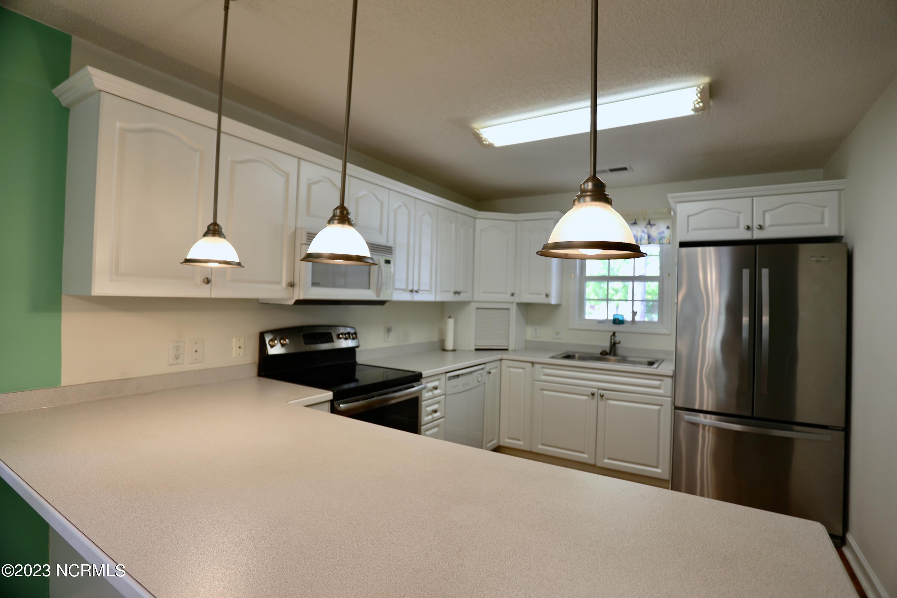 545 Pinehurst Trace Drive Pinehurst, NC 28374 - Photo 8 of 32 Kitchen is Bright with White Cabinetry & Counters