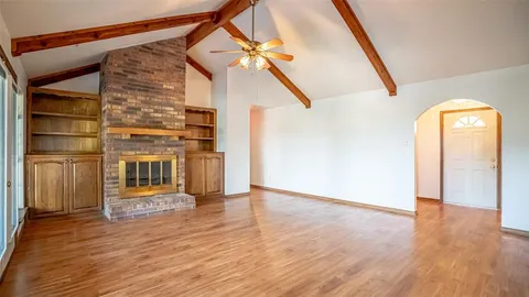 a view of a living room with wooden floor and entryway