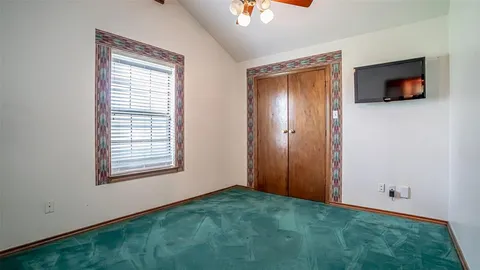 an empty room with a window and a ceiling fan