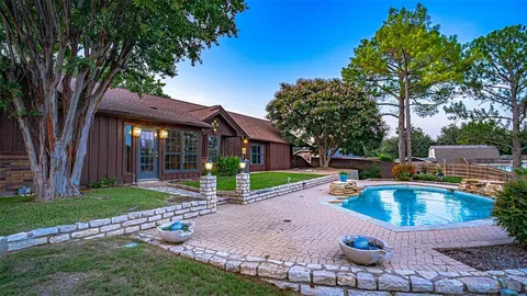 a front view of a house with swimming pool garden and patio