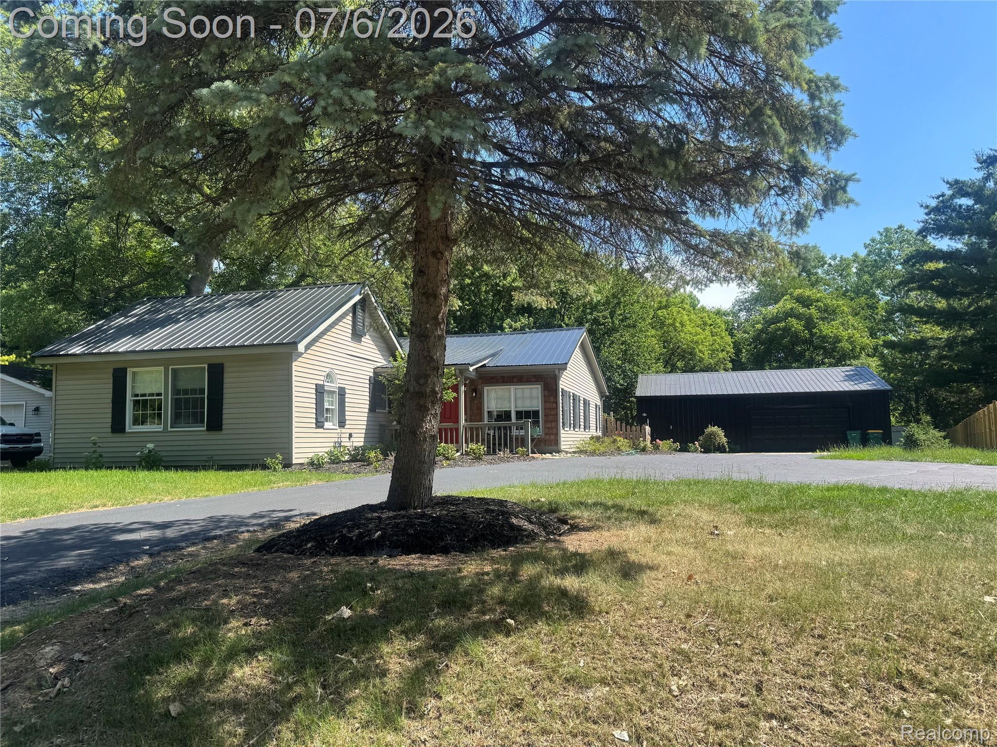 308 North Seymour Road Flushing, MI 48433 - Photo 5 of 5 Property exterior featuring light-colored siding, black shutters, and a gray metal roof