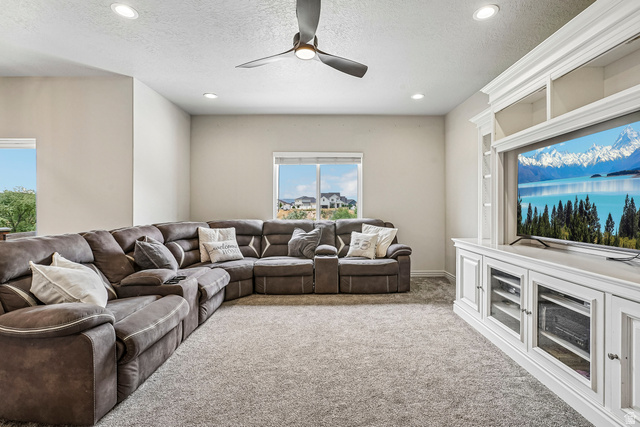 203 North 1900th Street West Mapleton, UT 84664 - Photo 5 of 48 Carpeted room featuring a ceiling fan with integrated lighting, recessed lighting, and a white built-in entertainment center with glass-front cabinetry