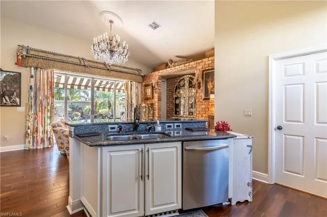 a kitchen with a sink and wooden floor