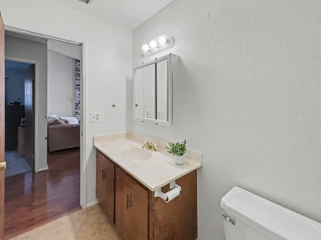a bathroom with a toilet sink and mirror