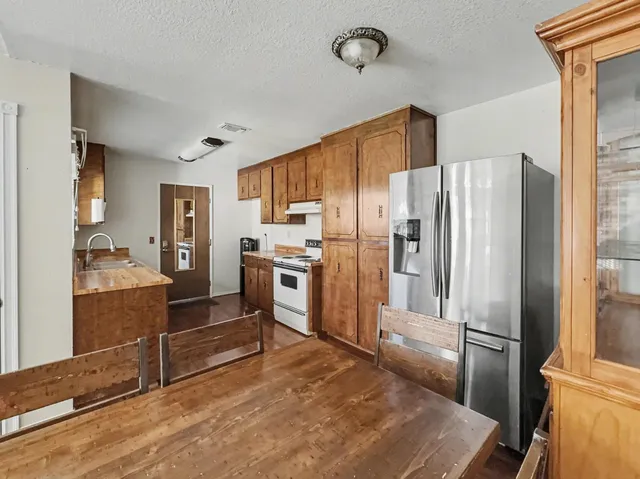 a kitchen with stainless steel appliances a refrigerator and a stove top oven