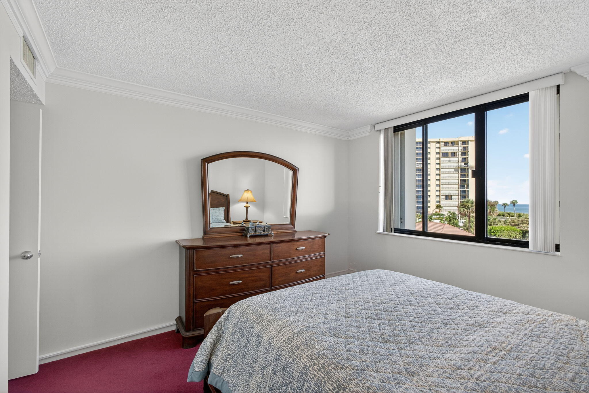 100 Ocean Trail Way, Unit 305 Jupiter, FL 33477 - Photo 23 of 90 a bedroom with a bed and a dresser next to a window