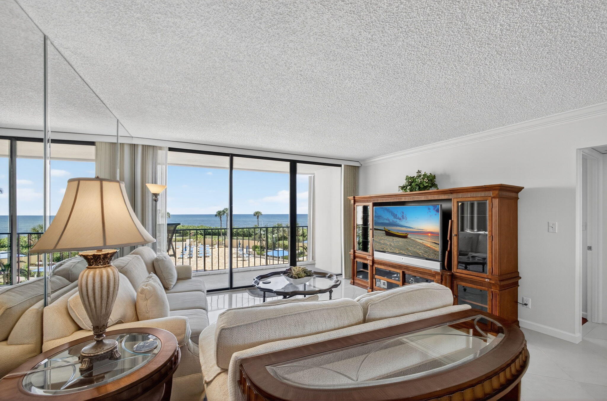 100 Ocean Trail Way, Unit 305 Jupiter, FL 33477 - Photo 3 of 90 a living room with furniture a flat screen tv and a floor to ceiling window