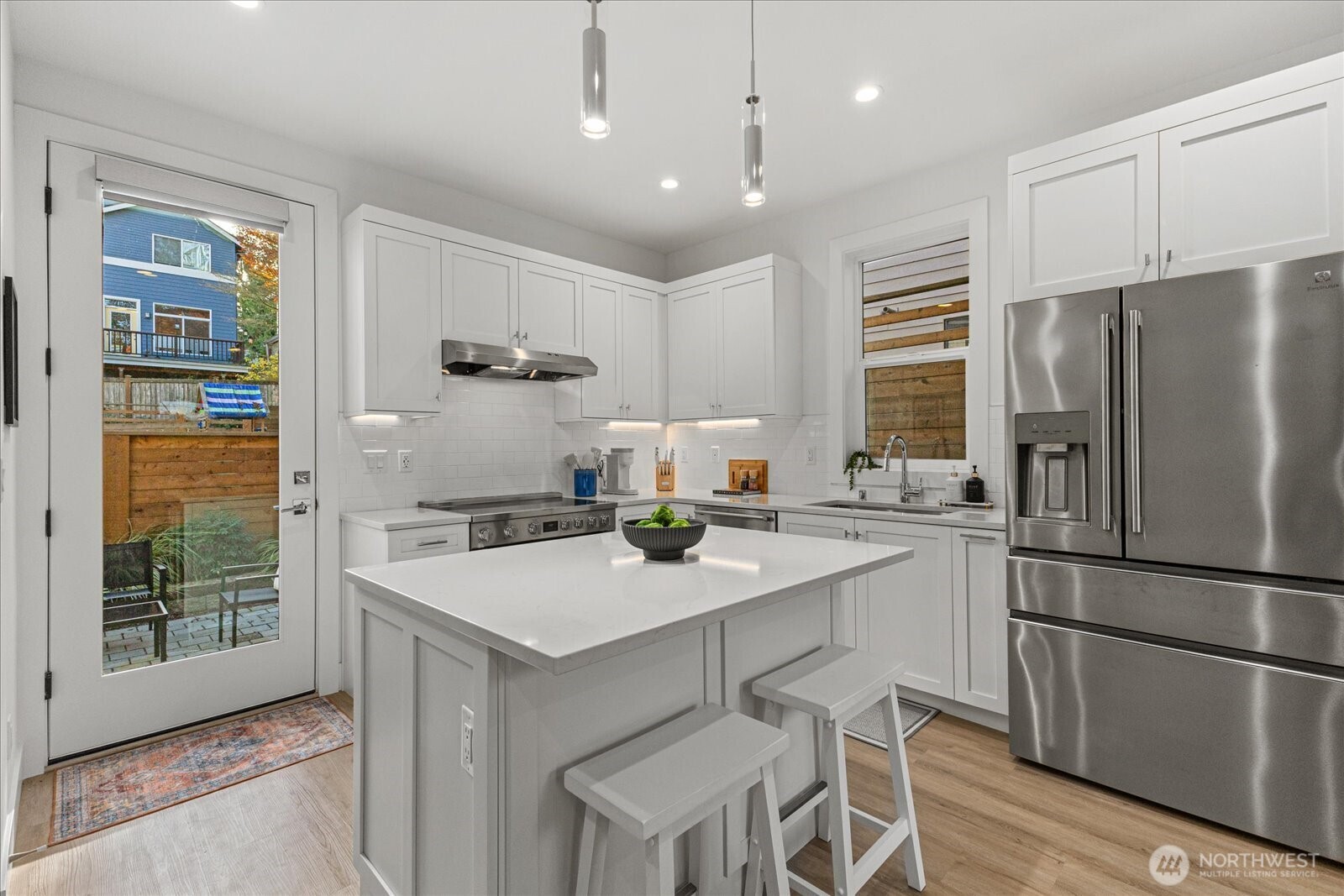 3537 Northeast 93rd Street Seattle, WA 98115 - Photo 8 of 22 a kitchen with stainless steel appliances granite countertop a refrigerator a sink a stove a dining table and chairs