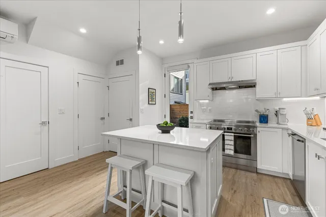 a kitchen with a sink a stove a refrigerator and white cabinets