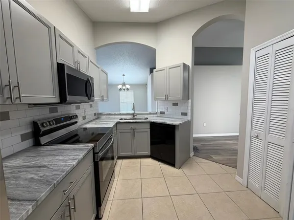 a kitchen with stainless steel appliances granite countertop a stove a sink and a microwave