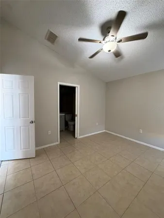 an empty room with fan and windows