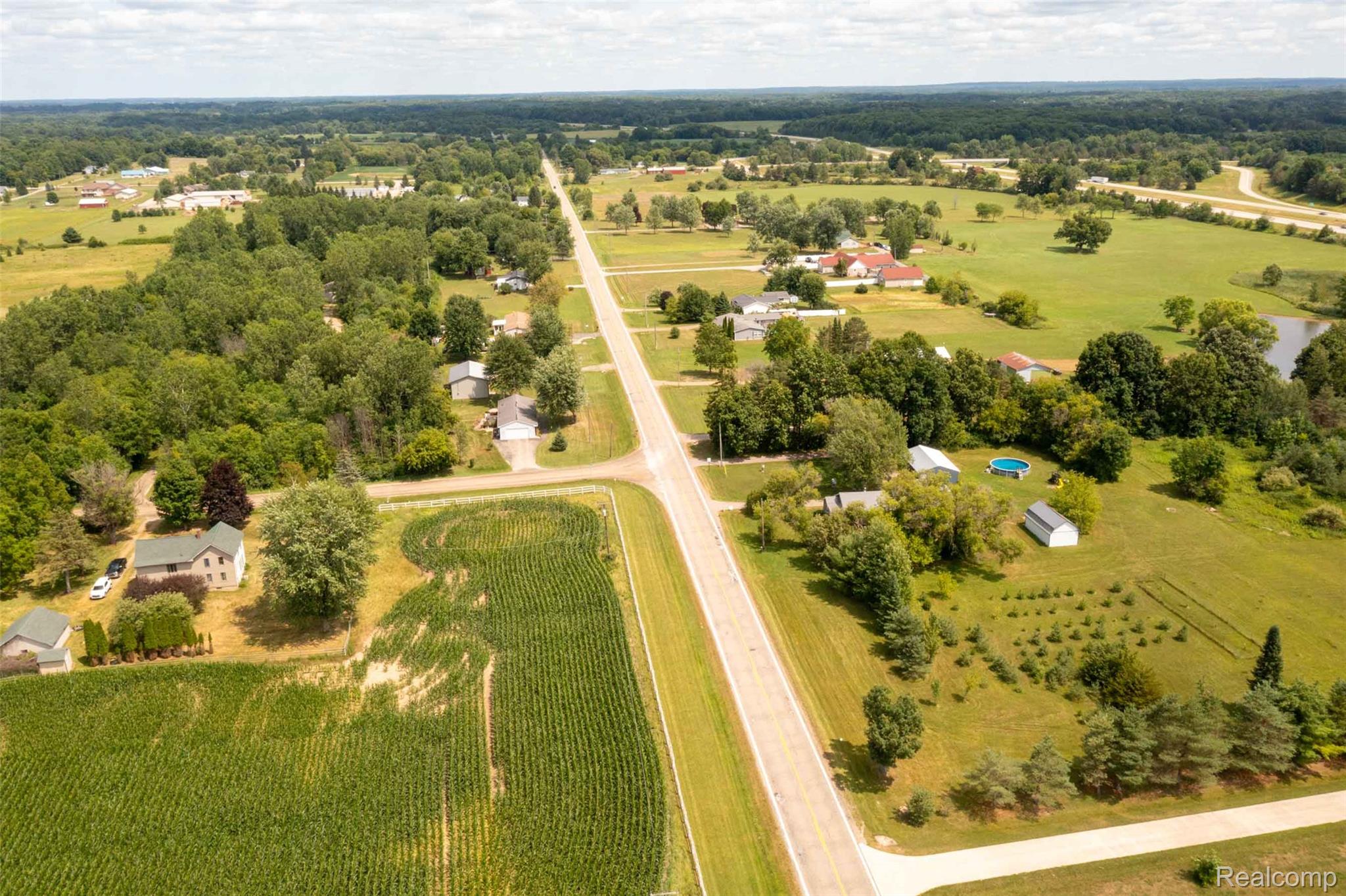 5761 Genesee Road Lapeer, MI 48446 - Photo 33 of 52 Expansive aerial perspective showcasing a rural landscape with residential properties interspersed among cultivated fields and mature tree lines