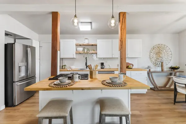 a kitchen with a dining table chairs and refrigerator