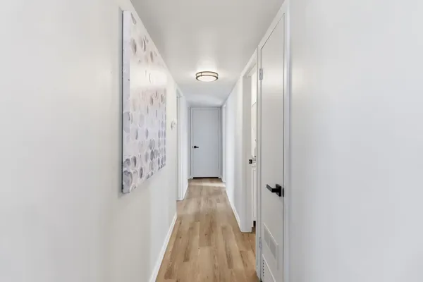a view of a hallway with wooden floor
