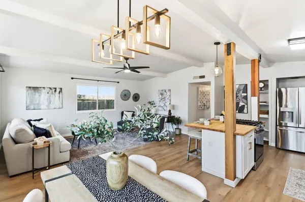 a living room with furniture potted plant and kitchen view