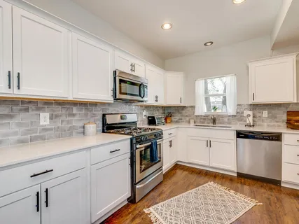 a kitchen with stainless steel appliances granite countertop a sink a stove a microwave and cabinets