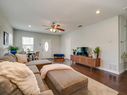 a living room with furniture and a wooden floor