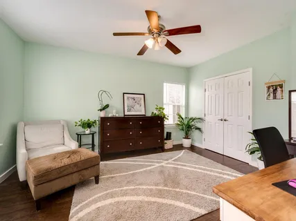 a living room with furniture and a ceiling fan