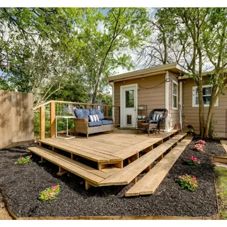 a view of a backyard with large trees and wooden fence