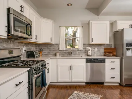 a kitchen with stainless steel appliances granite countertop a stove a sink and a microwave