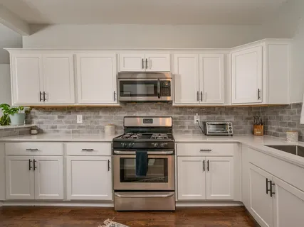 a kitchen with white cabinets and stainless steel appliances