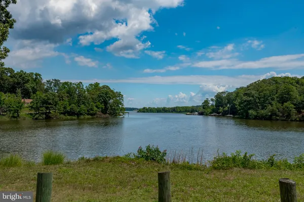 a view of a lake with a big yard and large trees