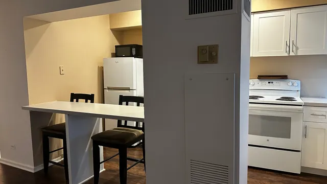 a kitchen with a stove cabinets and chair