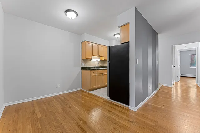 a view of a kitchen with wooden floor electronic appliances and a window