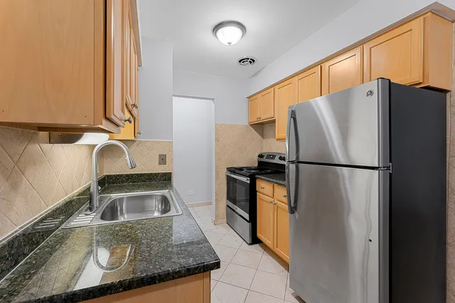 a kitchen with granite countertop a refrigerator and a sink
