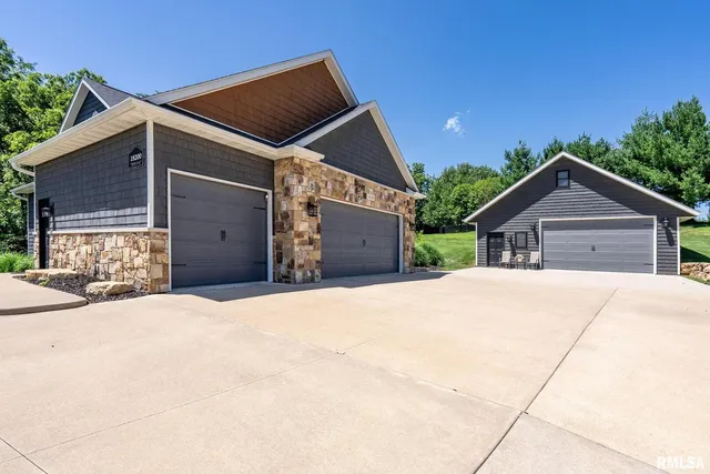 an aerial view of a residential houses with outdoor space and trees