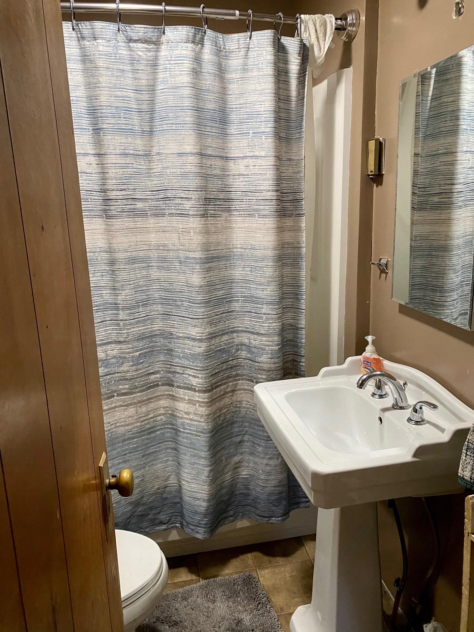 180 Perry Road Woodbine, NJ 08270 - Photo 5 of 6 a bathroom with a sink a toilet and shower curtain