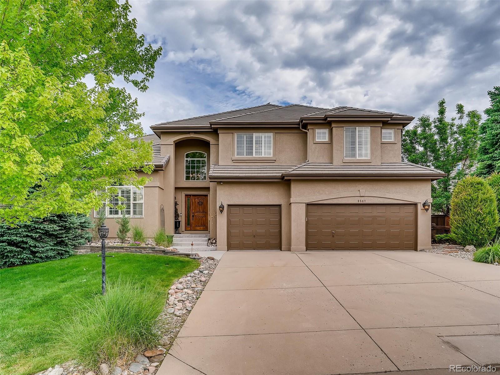 9567 East Aspen Hill Place Lone Tree, CO 80124 - Photo 1 of 38 a front view of a house with garden
