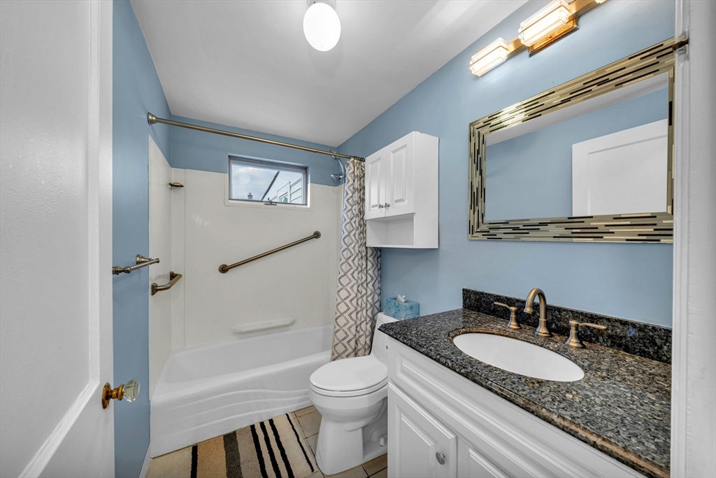 144 Orvis Road Revere, MA 02151 - Photo 14 of 42 a bathroom with a granite countertop sink toilet mirror vanity and shower