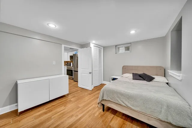 a spacious bedroom with a bed and a refrigerator