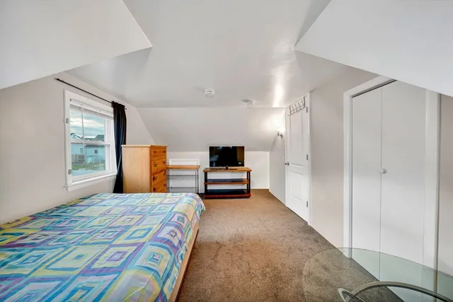 a bedroom with a bed and a large window