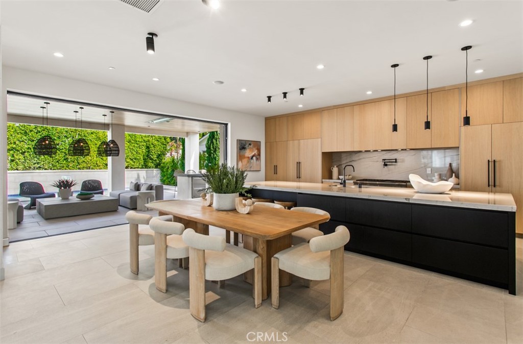 1210 Kings Road Newport Beach, CA 92663 - Photo 16 of 50 a kitchen with stainless steel appliances granite countertop a table chairs sink and cabinets