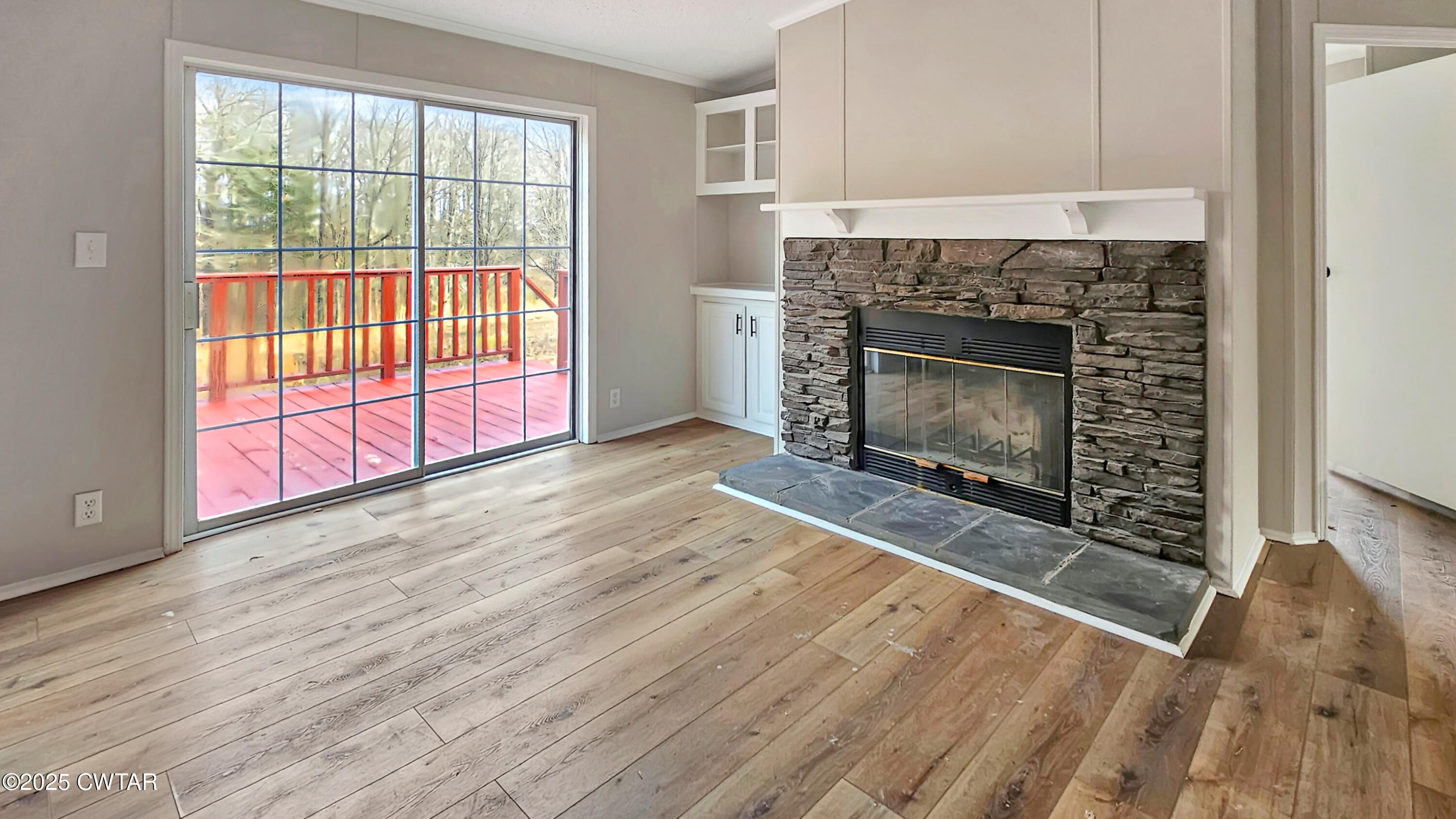 5427 Shades Bridge Road McKenzie, TN 38201 - Photo 14 of 35 an empty room with wooden floor fireplace and windows