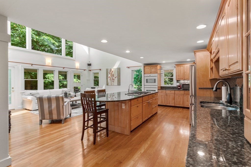 7 Phinney Road Lexington, MA 02421 - Photo 4 of 30 a kitchen with stainless steel appliances granite countertop a refrigerator a stove top oven a dining table and chairs with wooden floor