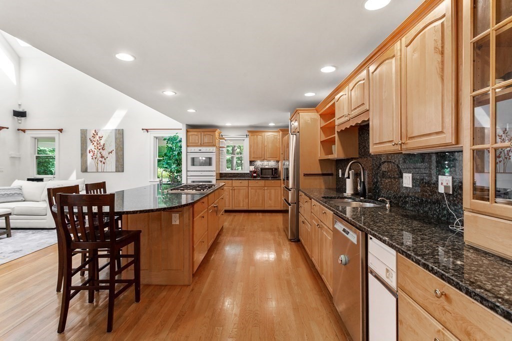 7 Phinney Road Lexington, MA 02421 - Photo 7 of 30 a large kitchen with stainless steel appliances granite countertop a stove a sink a dining table and chairs