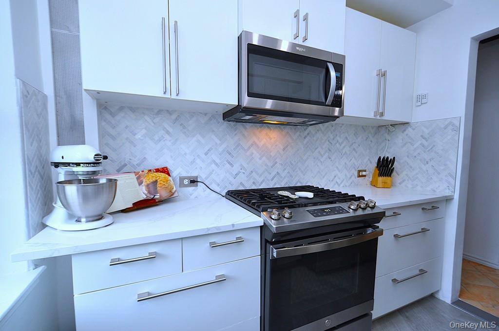 192 Garth Road, Unit TP Scarsdale, NY 10583 - Photo 12 of 43 The thoughtfully renovated kitchen is a chef’s delight, showcasing stainless steel appliances, custom white cabinetry, abundant quartz countertops, and generous workspace.