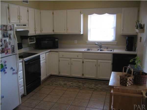 8823 Burning Tree Road Pensacola, FL 32514 - Photo 8 of 14 Kitchen with white cabinets,tile floor and updated appliances